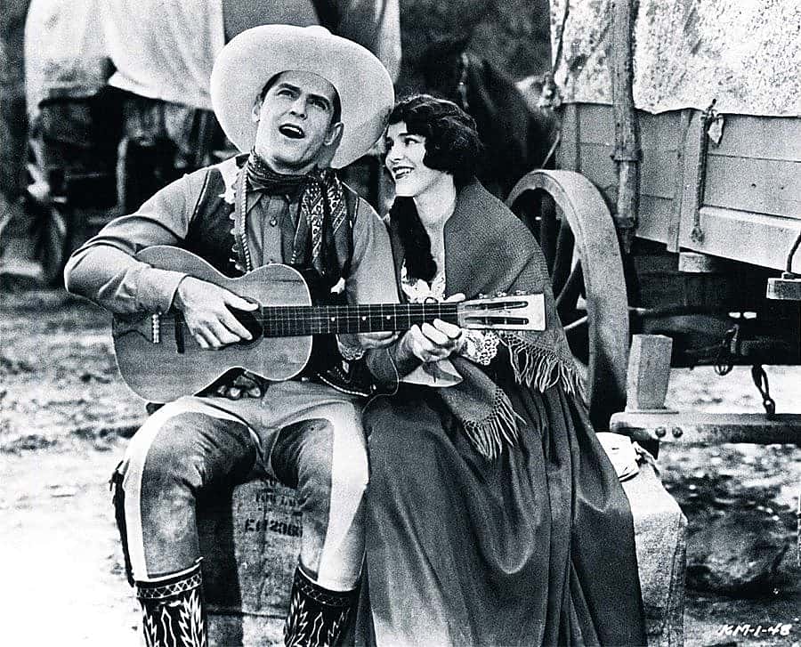 Cowboy movie star Ken Maynard singing to his co-star Edith Roberts in the 1929 Universal Maynard production "The Wagon Master" (Saturday Matinee).