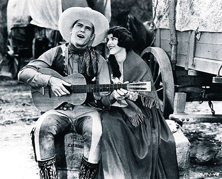 Cowboy movie star Ken Maynard singing to his co-star Edith Roberts in the 1929 Universal Maynard production "The Wagon Master" (Saturday Matinee).