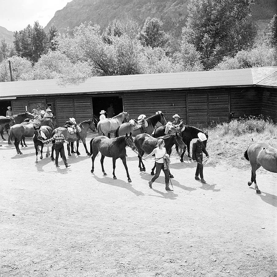 Guests with horses at Valley Ranch, with Absaroka Mountains in background. MS 89 Jack Richard Photograph Collection. P.89.37.8200.18-N