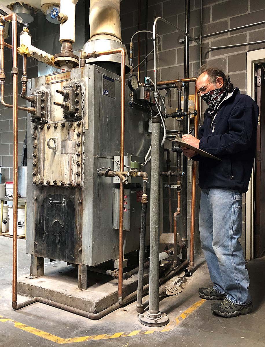 Operating Engineer Phil Anthony takes readings from the 30-year-old boiler in the Plains Indian Museum section of the Center. The only remaining steam boiler in the building, it is slated to be replaced with atomizer humidification.