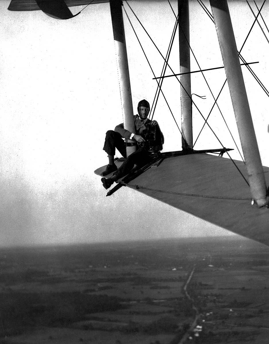 Harold McCracken perched on the wing of a plane with his camera. MS 305 Harold McCracken Photograph Collection, McCracken Research Library.