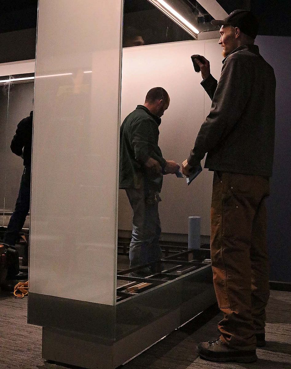 The exhibition crew shines acres of glass in the new Cody Firearms Museum. The cases are larger to accommodate more firearms, and have more glass to create better viewing for visitors.