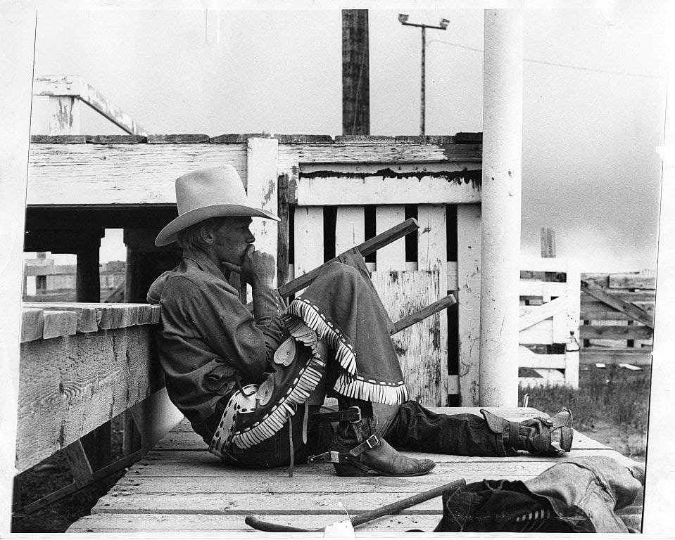 High school rodeo rider looking at stock