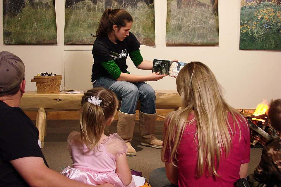 Jordan, another new volunteer, reading "Owl Babies" to a group of children and parents at our Halloween event.