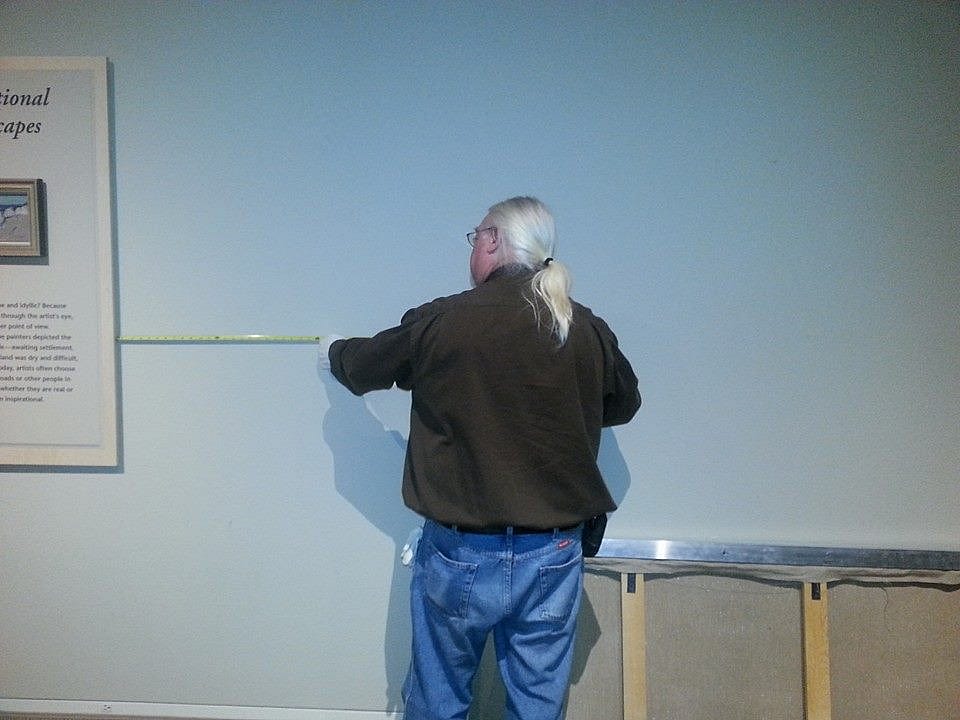 Gary from our Collections Department measuring the space to hang the painting.