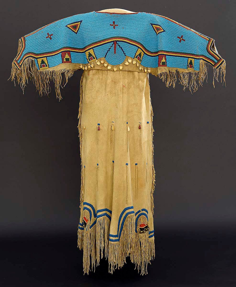 Fig. 8: One of the hundreds of treasures in the Paul Dyck Collection. Nineteenth-century dress of tradecloth, tanned hide, brass bells, beads, and elk teeth. The Paul Dyck Plains Indian Buffalo Culture Collection, acquired through the generosity of the Dyck family and additional gifts of the Nielson Family and the Estate of Margaret S. Coe. NA.202.1254