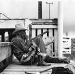 High school rodeo rider looking at stock