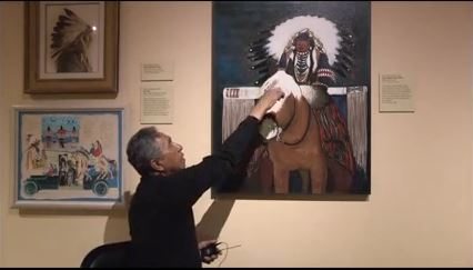 Kevin Red Star explains his color palette for the painting, Crow Indian Parade Rider