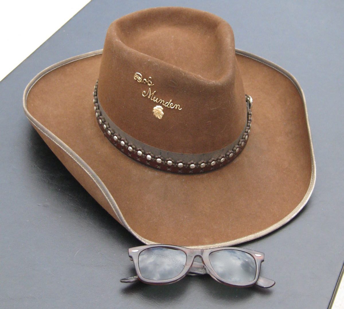 6/7. Two items that were synonymous with Bob were his cowboy hat and sunglasses. Bob wore both of these when performing exhibition shooting outdoors. At a mall in Boise, Idaho, one gentleman came up to the Mundens’ table at the food court and asked if he was addressing Bob Munden. Bob replied, "Just a minute." He pulled out his sunglasses from his shirt pocket, put them on, and the man exclaimed, "There you are!"
