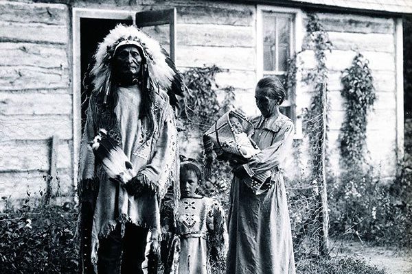 Standing Bear, Rose Two Bonnets, Lula Two Bonnets, and Louisa Standing Bear in front of their home, 1919. Photograph courtesy of Arthur Amiotte.