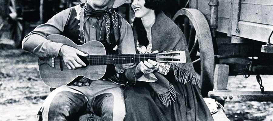 Cowboy movie star Ken Maynard singing to his co-star Edith Roberts in the 1929 Universal Maynard production "The Wagon Master" (Saturday Matinee).