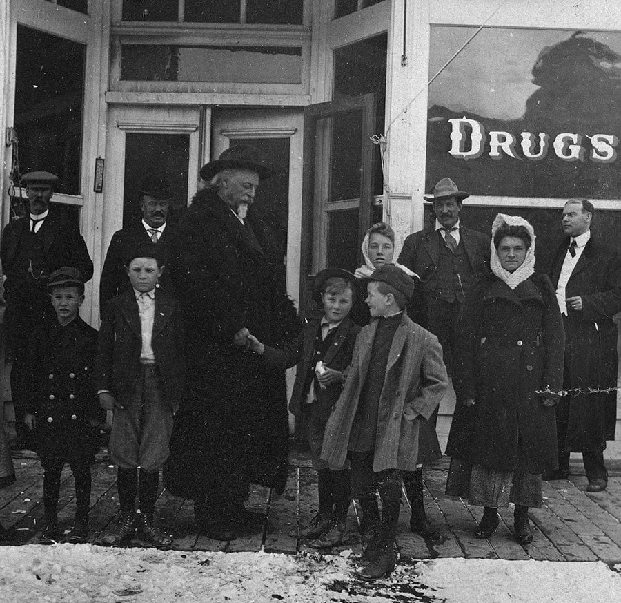 Youngsters loved Buffalo Bill. Here he shakes hands with a young admirer in front of the Meeteetse, Wyoming, drugstore, ca. 1913. MS6 William F. Cody Collection, McCracken Research Library. P.69.1153