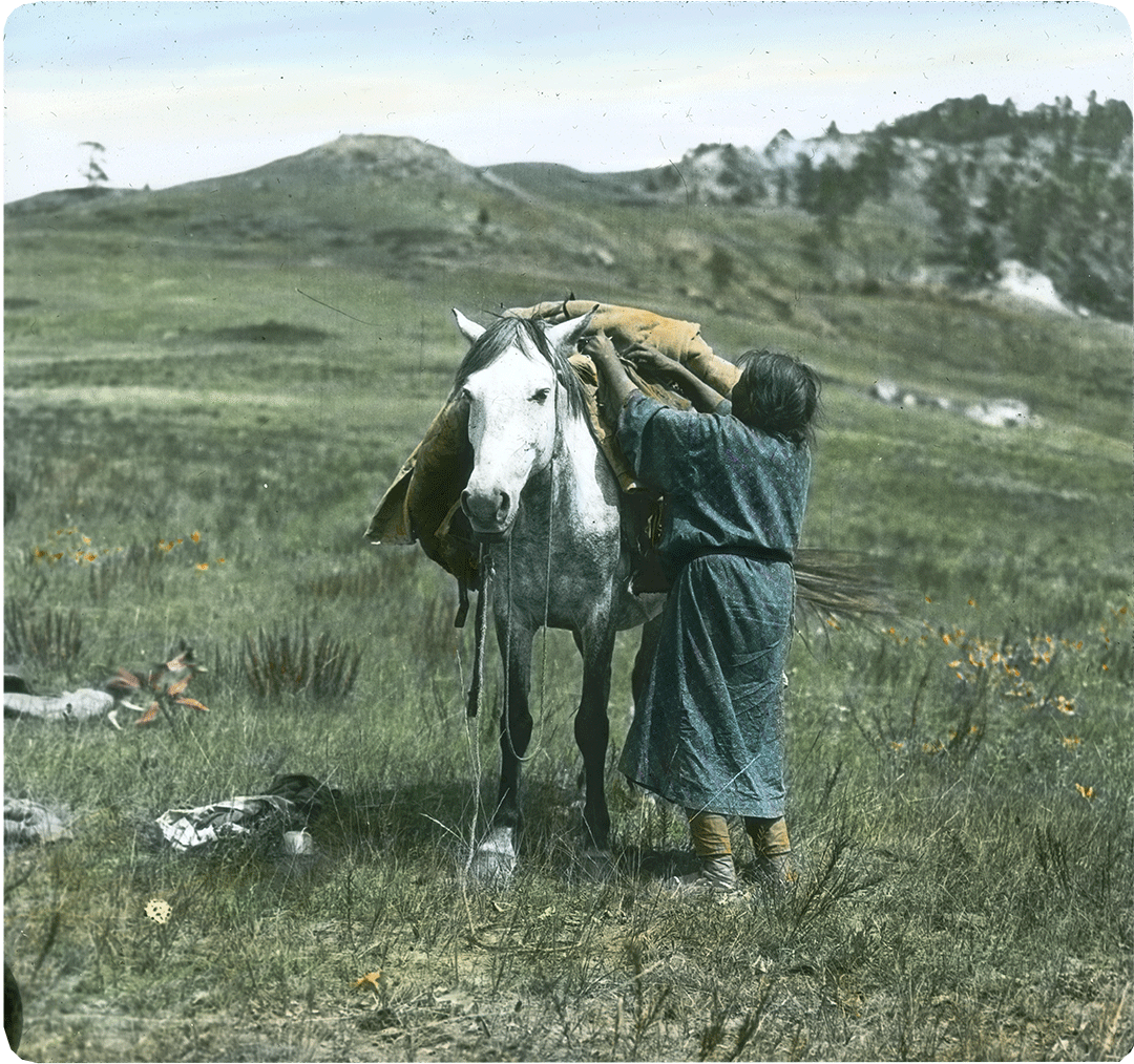 Unpacking at temporary camp, Absaroke (Crow). Colorized lantern slide. MS 95 William A. Petzoldt Lantern Slides Collection. LS.95.73
