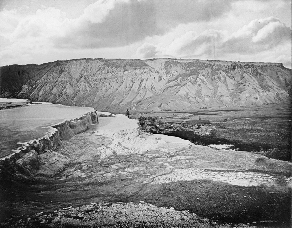 Yellowstone as revealed through the Albertype prints of William Henry Jackson. In this example, we see Mammoth Hot Springs, Mt. Everts in the background, the painter Thomas Moran posed on a ledge, and the negative altered to show puffy clouds. It is all there, the detail, the composition, the art, and the beauty of Jackson's Yellowstone. WHJ-A.064