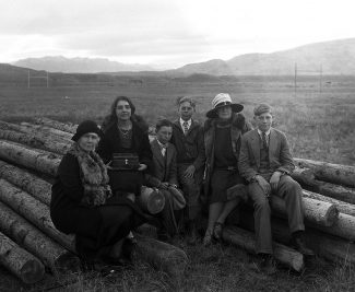 A Treasure from Our West: (L–R) Mary Jester Allen (1875–1960); Jane Garlow (1909–1987); George Walliker, the Garlow children's cousin; Bill Garlow (1913–1992); Geneva Garlow Walliker, Fred Garlow's sister and the Garlow children's aunt and caretaker; and Fred Garlow Jr. (1911–1985) sitting on logs at the construction site of the original Buffalo Bill Museum in downtown Cody, Wyoming. PN.228.146