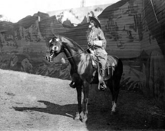 Photograph, William F. "Buffalo Bill" Cody in the Wild West arena against backdrop,, ca. 1913. MS 6 William F. Cody Collection. P.69.740