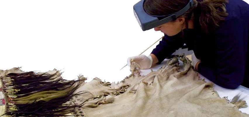 Tara Griffin, who served as a conservation intern in 2010, begins her work with a close examination of an artifact from the Paul Dyck Plains Indian Buffalo Culture Collection. Man's shirt, Upper Missouri River, ca. 1840s. The Paul Dyck Plains Indian Buffalo Culture Collection, acquired through the generosity of the Dyck family and additional gifts of the Nielson Family and the Estate of Margaret S. Coe. NA.202.1218