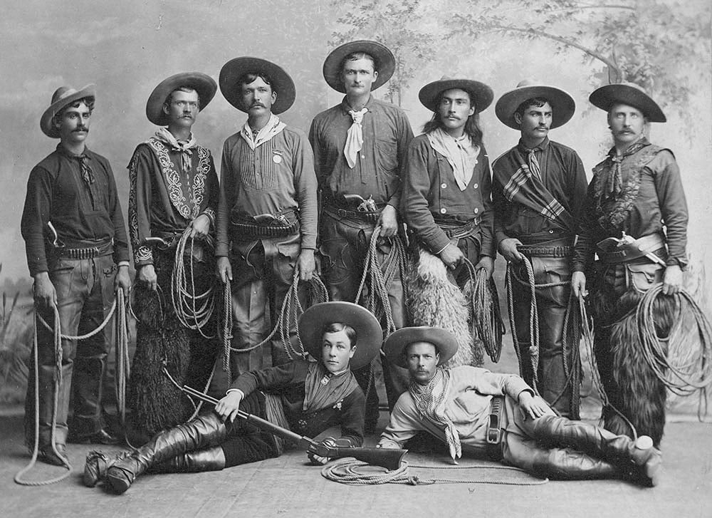 Young cowboys from Buffalo Bill's Wild West, 1886, posing with their guns and chaps. MS 6 William F. Cody Collection. P.6.86