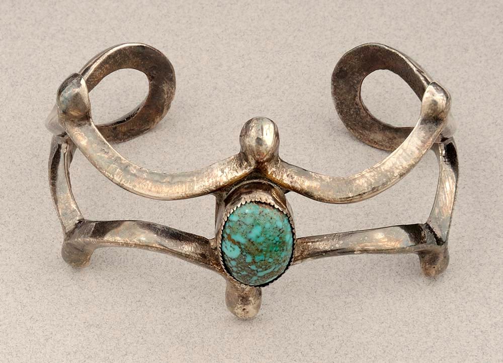 Note the bezel securing the turquoise stone in the center of this Navajo-style silver cast bracelet, 20th century. Gift of Margo Grant Walsh, in Appreciation of Ann Simpson. 1.69.6358
