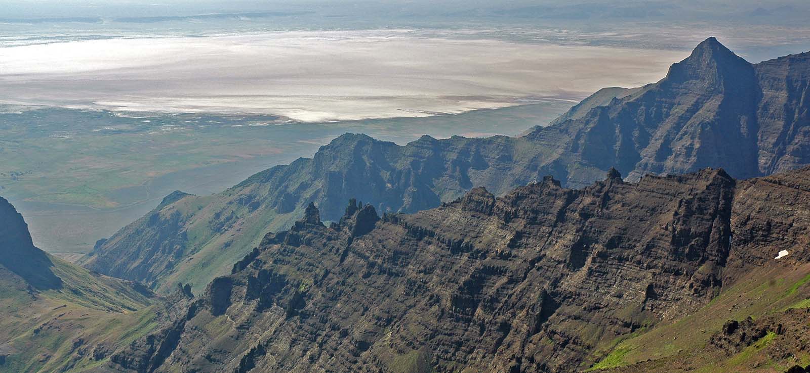 Steens Mountain escarpment of eastern Oregon, looking east into the Alvord basin. The escarpment is composed of thin lava flows cut by vertical dikes that feed the initial eruptions of the Columbia River flood basalts. These 17-million-year-old basalts represent the first direct manifestation of the Yellowstone hotspot.