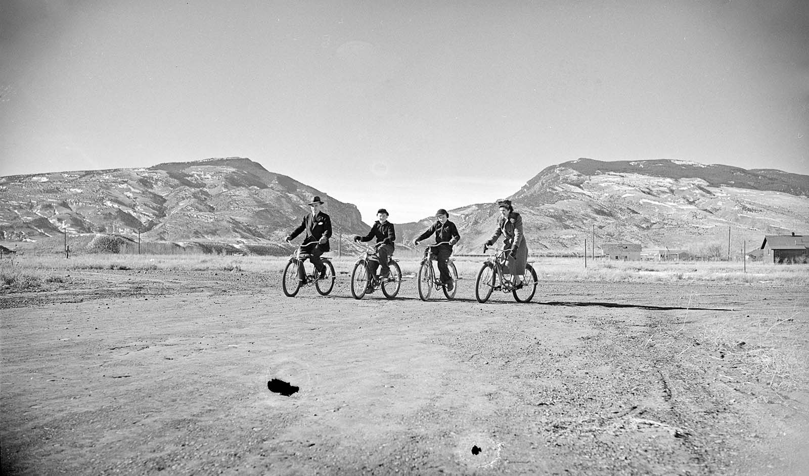 Milward and Lorna Simpson with sons Alan and Pete on bikes in Cody with Shoshone Canyon in background. PN.89.107.21020.02.5