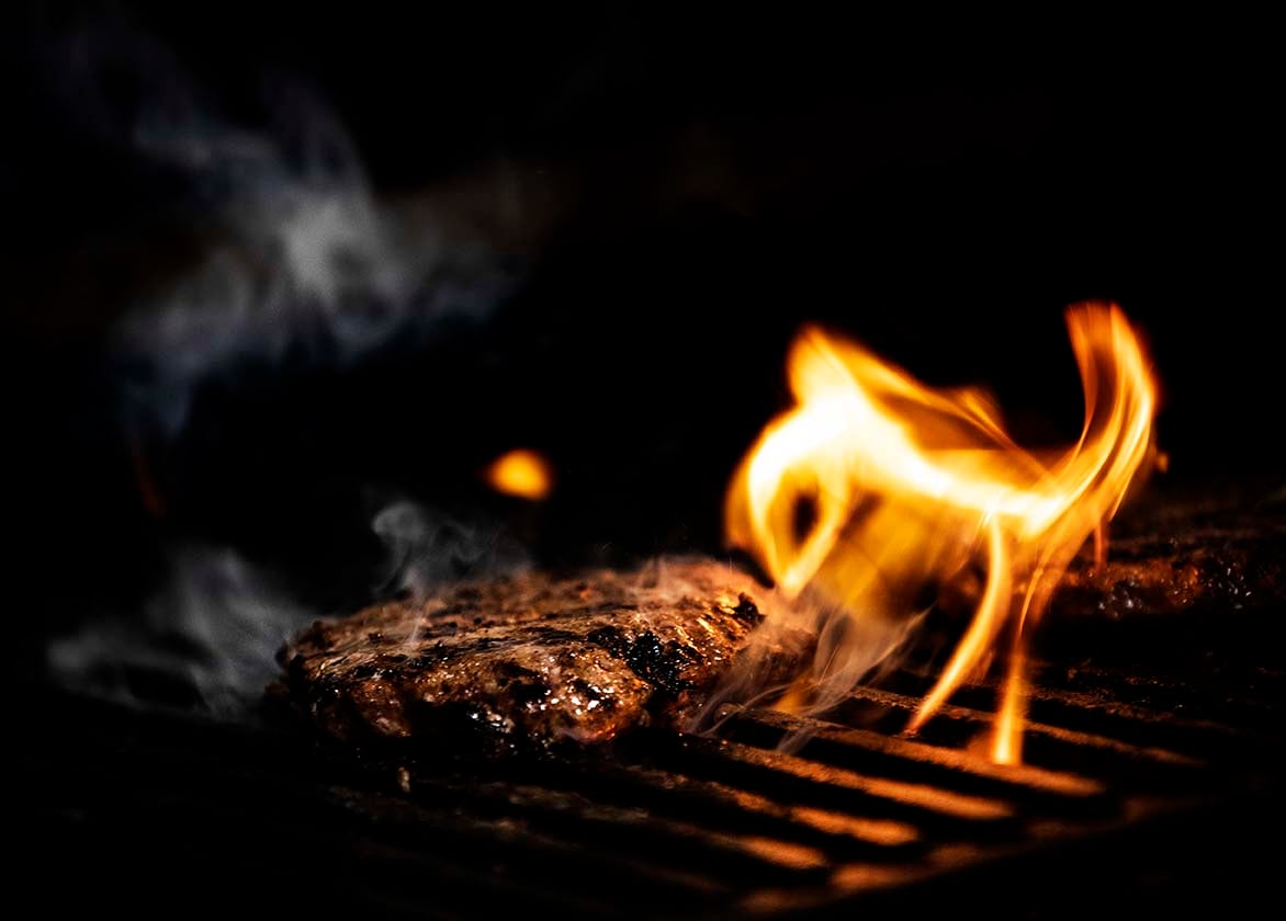 Burger on grill with flame