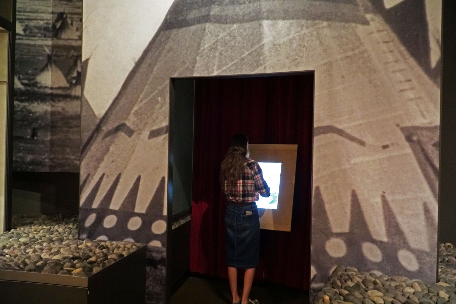 A visitor using the Land of Many Gifts interactive kiosk in the Plains Indian Museum.