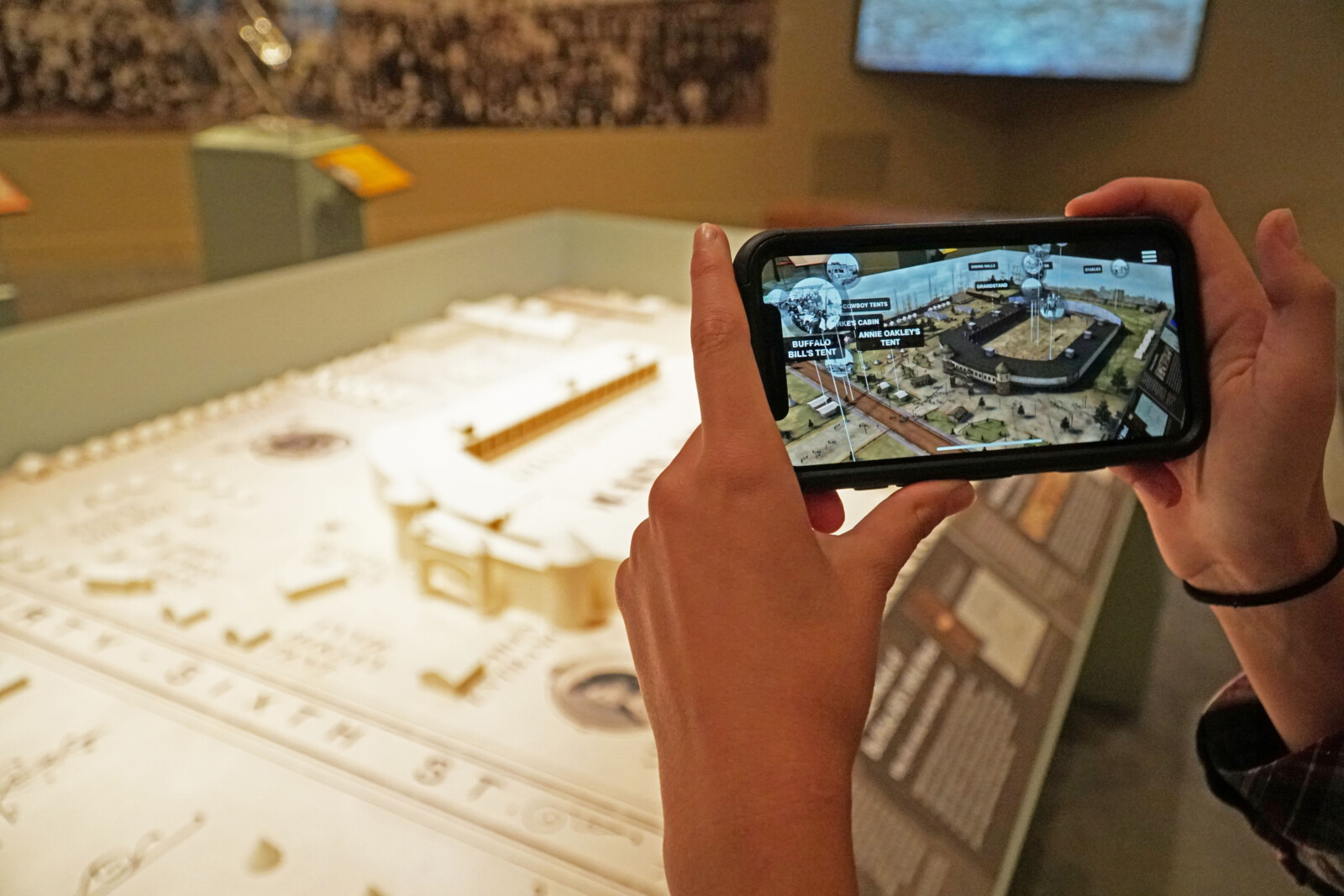 A visitor using their phone at Buffalo Bill's Wild West AR exhibit in the Buffalo Bill Museum.