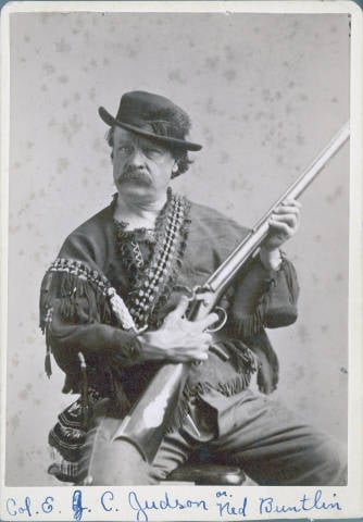 Ned Buntline in frontier garb, posing with a rifle.