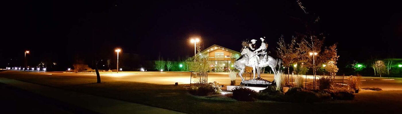 Code of the West sculpture at night